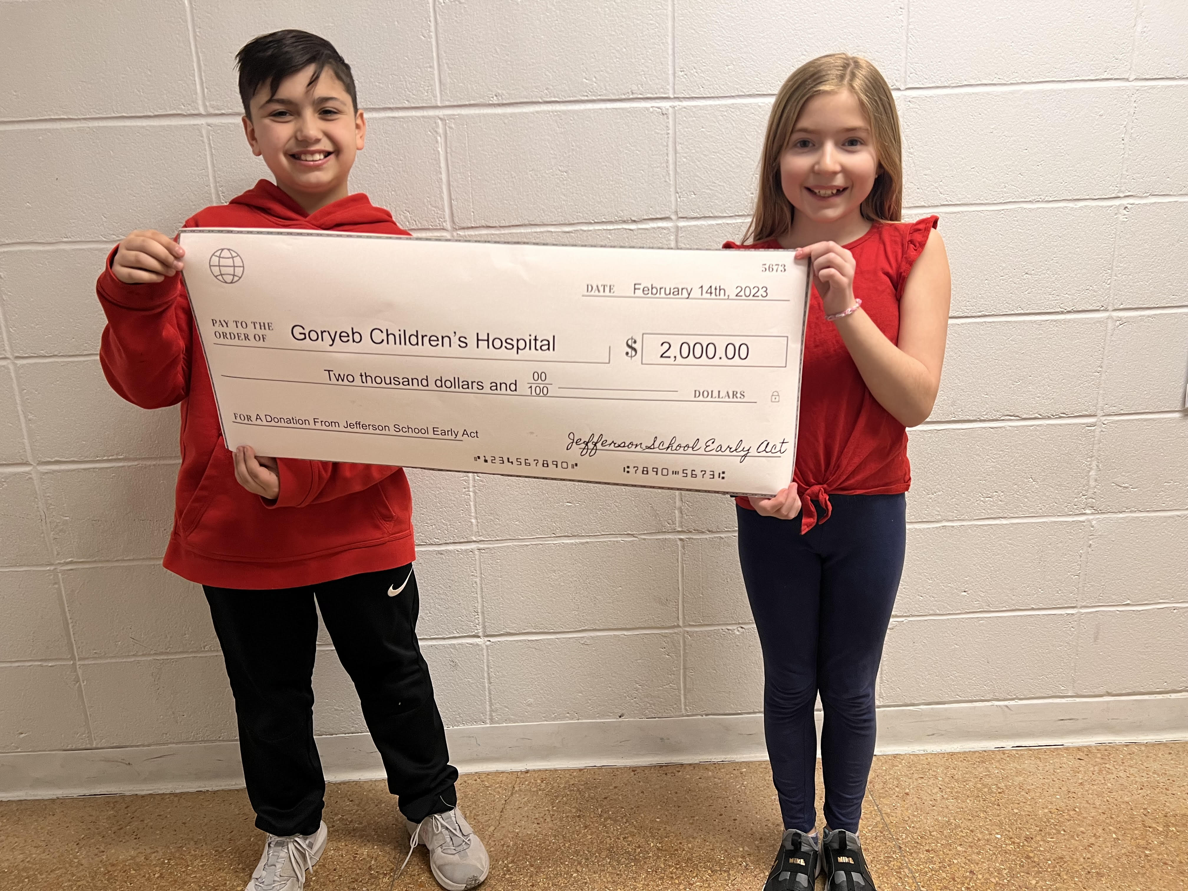 Early Act President Bryan Piazza and VP Sydney Schutz hold $2K Check for Goryeb